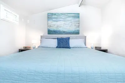 a bedroom with a large bed with a blue comforter at Updated 3Br Beach Home W Patio And Bbq, In Prime Location By Beachview Rentals in Newport Beach