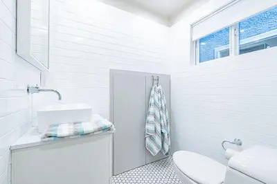 a white bathroom with a sink and a toilet at Updated 3Br Beach Home W Patio And Bbq, In Prime Location By Beachview Rentals in Newport Beach