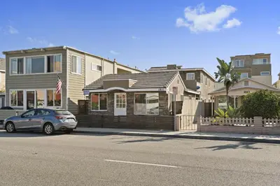 a car parked in front of houses on a street at Cozy 2Br Cottage W Ac, Prime Location One House From Sand By Beachview Rentals in Newport Beach