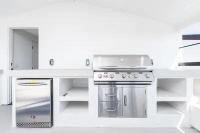 a kitchen with a stainless steel stove and cabinets at Luxury 3Br W Rooftop Deck, Grill, Ac, Steps From The Sand By Beachview Rentals in Newport Beach