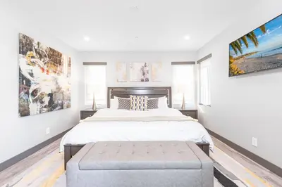 a bedroom with a large bed and a large painting on the wall at Luxury 4Br Tri-Level W Modern Interior, Rooftop Deck, Ac By Beachview Rentals in Newport Beach