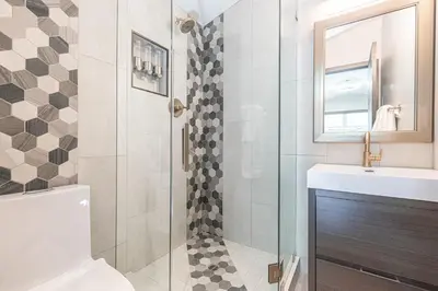 a bathroom with a shower and a toilet and a sink at Luxury 4Br Tri-Level W Modern Interior, Rooftop Deck, Ac By Beachview Rentals in Newport Beach