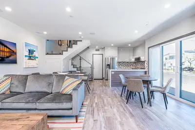 a living room with a couch and a table at Luxury 4Br Tri-Level W Modern Interior, Rooftop Deck, Ac By Beachview Rentals in Newport Beach