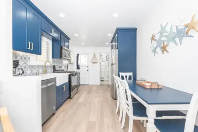 a kitchen with blue cabinets and a blue table and chairs at Updated 2Br Vintage Cottage In Central Location Near Beach By Beachview Rentals in Newport Beach