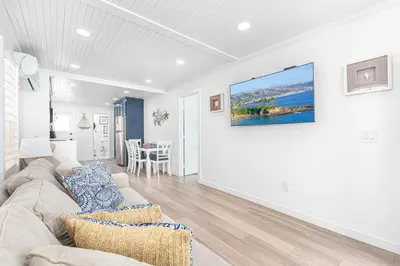 a living room with a couch and a painting on the wall at Updated 2Br Vintage Cottage In Central Location Near Beach By Beachview Rentals in Newport Beach