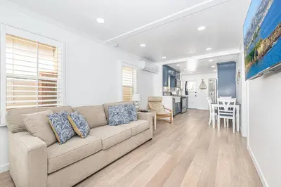 a living room with a couch and a table at Updated 2Br Vintage Cottage In Central Location Near Beach By Beachview Rentals in Newport Beach