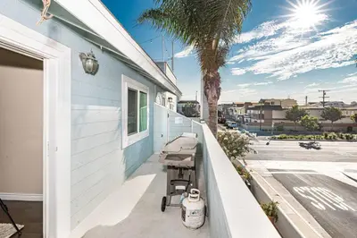 a porch with a stroller next to a house at Cozy 1Br Beach Retreat W Balcony, One Block From The Sand By Beachview Rentals in Newport Beach