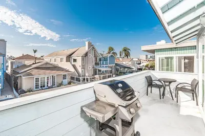 a balcony with a grill and a table and chairs at Cozy 1Br Beach Retreat W Balcony, One Block From The Sand By Beachview Rentals in Newport Beach