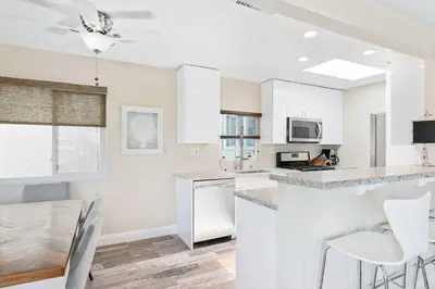 a kitchen with white cabinets and a table and chairs at Stylish 2Br Upstairs Cottage W Ac One House From Beach By Beachview Rentals in Newport Beach