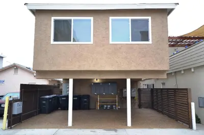 a house with a porch with a fence at Cozy Cottage W Ac, Stylish Interior, One House From Beach By Beachview Rentals in Newport Beach