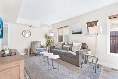 a living room with a couch and a table at Cozy Cottage W Ac, Stylish Interior, One House From Beach By Beachview Rentals in Newport Beach