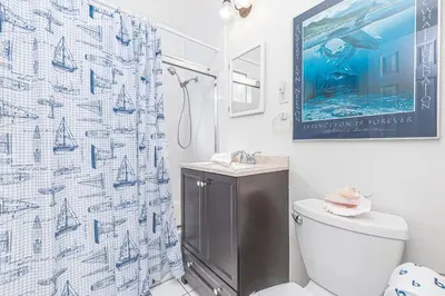 a bathroom with a toilet and a shower curtain at Pet-Friendly 3Br W Sun Deck, And Bbq, One Block To Beach By Beachview Rentals in Newport Beach