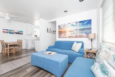 a living room with a blue couch and a table at Pet-Friendly 3Br W Sun Deck, And Bbq, One Block To Beach By Beachview Rentals in Newport Beach
