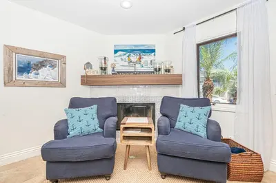 a living room with two chairs and a fireplace at Luxury 5Br Vacation Home W Rooftop Deck, Ocean Views, Ac By Beachview Rentals in Newport Beach