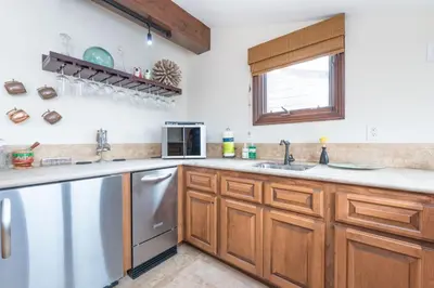 a kitchen with wooden cabinets and stainless steel appliances at Luxury 5Br Vacation Home W Rooftop Deck, Ocean Views, Ac By Beachview Rentals in Newport Beach