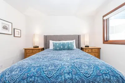 a bedroom with a blue bed with two night stands at Luxury 5Br Vacation Home W Rooftop Deck, Ocean Views, Ac By Beachview Rentals in Newport Beach