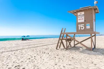 a lifeguard stand on a beach with a sign at Cozy 2Br W Large Deck, Steps From Marina Park And Beach By Beachview Rentals in Newport Beach