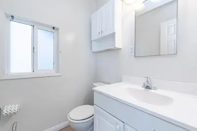 a white bathroom with a sink and a toilet at 3Br Oceanfront In Desirable Location At Excellent Value By Beachview Rentals in Newport Beach