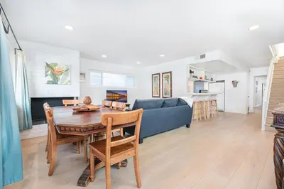 a living room with a table and a blue couch at Quiet 4Br Home W Large Deck And Bbq, 2 Blocks From Sand By Beachview Rentals in Newport Beach