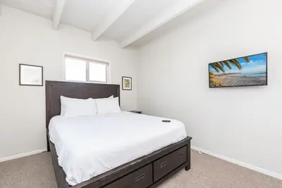 a bedroom with a large bed with white sheets at Cozy 2Br Upstairs Cottage Steps From Sand In Prime Location By Beachview Rentals in Newport Beach