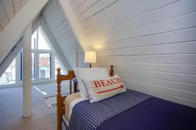 a bedroom with a bed with a pillow on it at Retro A-Frame Studio W Loft And Sun Deck, Steps From Sand By Beachview Rentals in Newport Beach