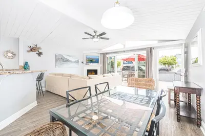 a living room with a table and chairs at 3Br Beach Cottage W Large Patio And Grill, Prime Location By Beachview Rentals in Newport Beach