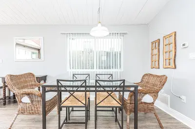 a dining room with a black table and chairs at 3Br Beach Cottage W Large Patio And Grill, Prime Location By Beachview Rentals in Newport Beach