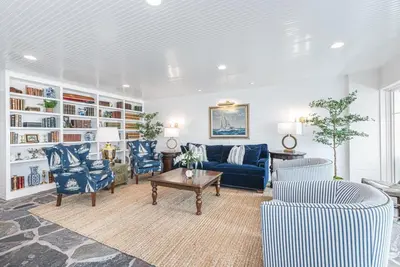 a living room with a blue couch and chairs at Spectacular 6Br Oceanfront Home In Highly-Coveted Location By Beachview Rentals in Newport Beach