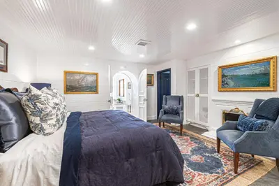 a bedroom with a bed and two chairs and a fireplace at Spectacular 6Br Oceanfront Home In Highly-Coveted Location By Beachview Rentals in Newport Beach