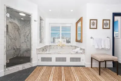 a white bathroom with a tub and a window at Spectacular 6Br Oceanfront Home In Highly-Coveted Location By Beachview Rentals in Newport Beach