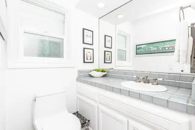 a white bathroom with a sink and a mirror at Luxe Oceanfront 3Br W Rooftop Deck, Pier To Pier Location By Beachview Rentals in Newport Beach