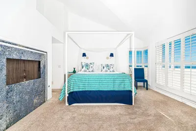 a white bedroom with a bed and a tv at Luxe Oceanfront 3Br W Rooftop Deck, Pier To Pier Location By Beachview Rentals in Newport Beach