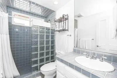 a bathroom with a toilet and a sink and a mirror at Luxe Oceanfront 3Br W Rooftop Deck, Pier To Pier Location By Beachview Rentals in Newport Beach