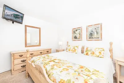 a bedroom with a bed and a tv on a wall at Luxe Oceanfront 3Br W Rooftop Deck, Pier To Pier Location By Beachview Rentals in Newport Beach