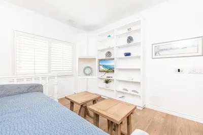 a bedroom with a bed and a table at Luxe Oceanfront 3Br W Rooftop Deck, Pier To Pier Location By Beachview Rentals in Newport Beach