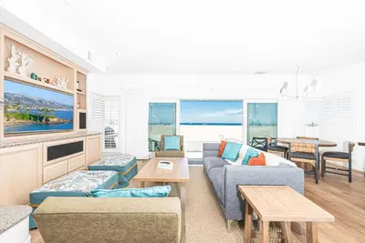 a living room with a couch and a table at Luxe Oceanfront 3Br W Rooftop Deck, Pier To Pier Location By Beachview Rentals in Newport Beach