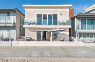 a house with a patio with an umbrella at 3Br Oceanfront In Desirable Location At Excellent Value By Beachview Rentals in Newport Beach