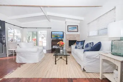 a living room with white furniture and a fireplace at Charming 1Br Beach Cottage W Large Patio One Block To Sand By Beachview Rentals in Newport Beach