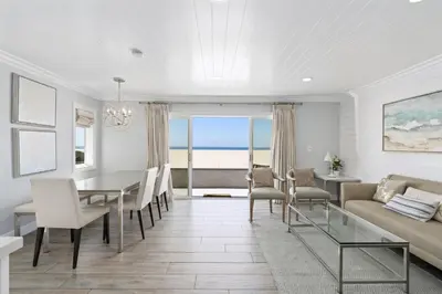 a living room with a table and chairs and a couch at Stylish 3Br Oceanfront W Gorgeous Views, Boardwalk Access By Beachview Rentals in Newport Beach
