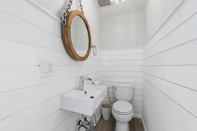 a white bathroom with a toilet and a mirror at Stylish 3Br Oceanfront W Gorgeous Views, Boardwalk Access By Beachview Rentals in Newport Beach