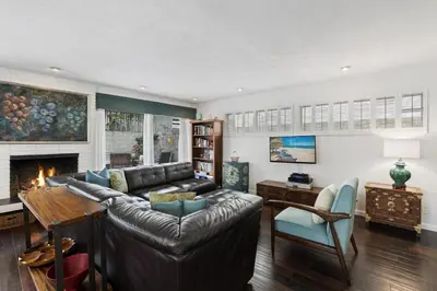 a living room with a leather couch and a fireplace at Affordable 3Br Near Beach, Walk To Shops, Dining And More By Beachview Rentals in Newport Beach