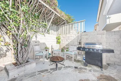 a patio with a grill and chairs and a table at Affordable 3Br Near Beach, Walk To Shops, Dining And More By Beachview Rentals in Newport Beach
