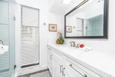 a white bathroom with a sink and a mirror at Iconic 4Br Bayfront Home W Unmatched Indooroutdoor Living By Beachview Rentals in Newport Beach