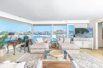 a living room with a view of the water at Iconic 4Br Bayfront Home W Unmatched Indooroutdoor Living By Beachview Rentals in Newport Beach