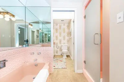 a pink bathroom with a tub and a toilet at Iconic 4Br Bayfront Home W Unmatched Indooroutdoor Living By Beachview Rentals in Newport Beach