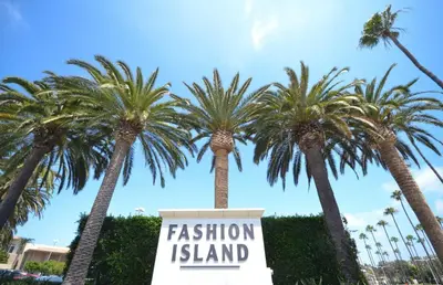 a sign that reads fashion island in front of palm trees at Iconic 4Br Bayfront Home W Unmatched Indooroutdoor Living By Beachview Rentals in Newport Beach