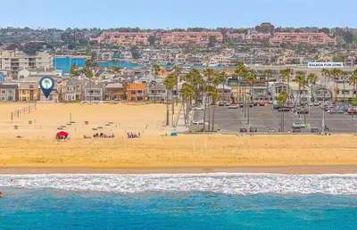 a beach with a group of people on the sand at Affordable 2Br Oceanfront W Large Patio, Boardwalk Access By Beachview Rentals in Newport Beach