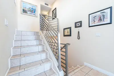 a staircase in a home with paintings on the wall at Affordable 2Br Oceanfront W Large Patio, Boardwalk Access By Beachview Rentals in Newport Beach