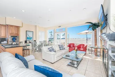 a living room with a white couch and a table at Affordable 2Br Oceanfront W Large Patio, Boardwalk Access By Beachview Rentals in Newport Beach