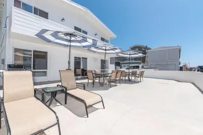 a patio with chairs and tables and umbrellas at 3Br W Oceanview Patio, 1 House From Popular 40Th St Beach By Beachview Rentals in Newport Beach